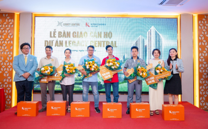 Bà Nguyễn Ngọc Ánh và ông Omori Daisuke (bìa trái), Tổng giám đốc Công ty Anabuki NL Housing Service Việt Nam trao chìa khóa tượng trưng và tặng hoa, quà chúc mừng cư dân Legacy Central nhận bàn giao căn hộ sáng 11/5. Ảnh: Thanh Sơn